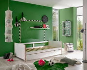 Weißes Jugendbett in einem sportlich dekorierten Zimmer mit grüner Wand, Fußball-Dekorationen und einem Tischkicker an der Wand. Perspektive: seitlich von vorne.