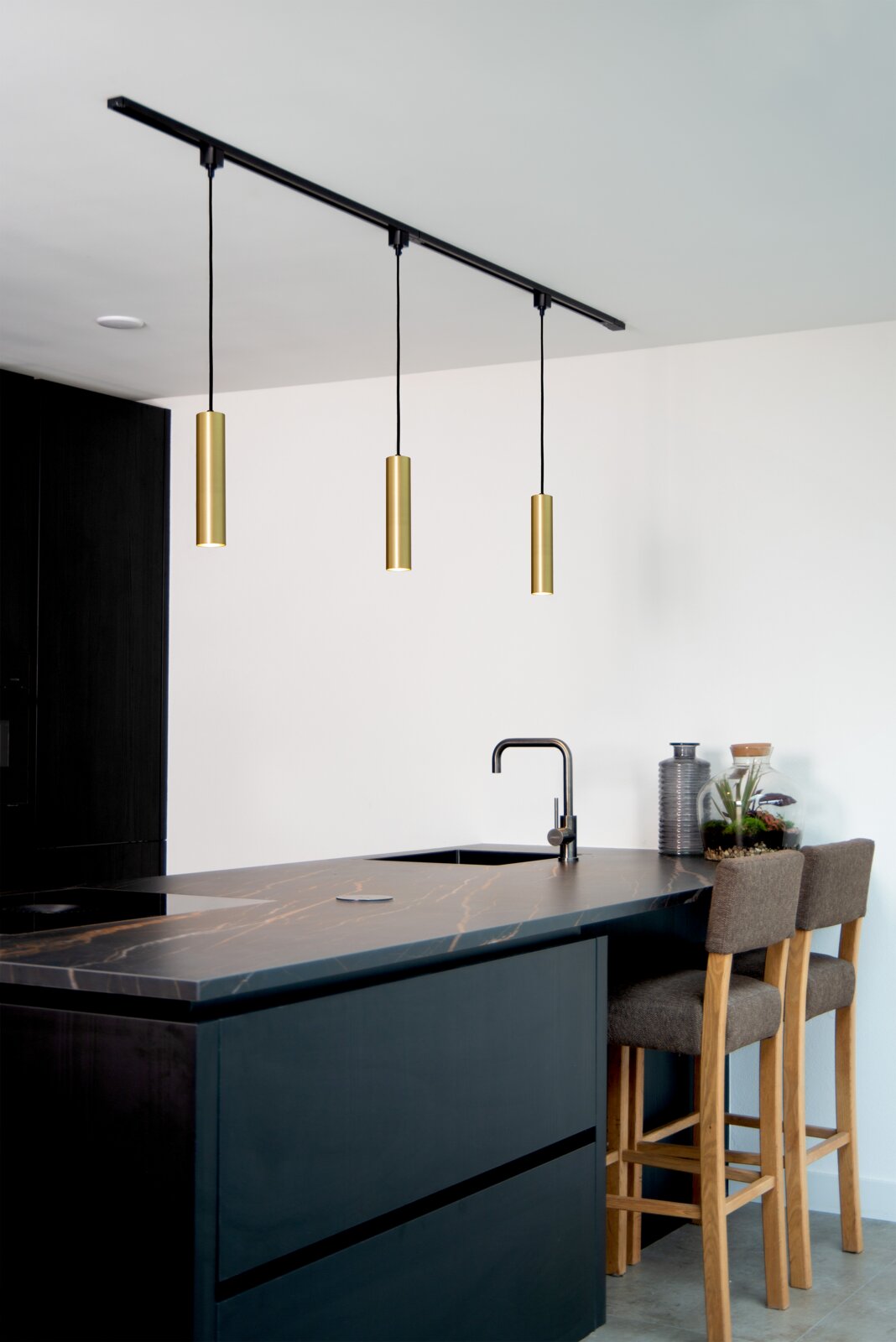 Moderne Pendelleuchte FLORIS in mattgoldener Ausführung, dreifach über einer Kücheninsel hängend, seitliche Perspektive.