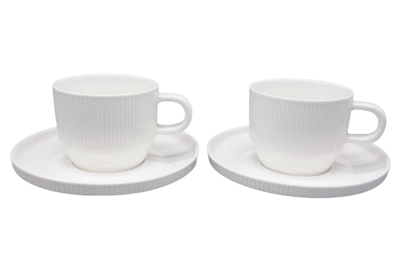 Zurbrüggen Cappuccinotasse 4-tlg. Zwei weiße Porzellan-Kaffeetassen mit Untertassen und feiner Rillenstruktur, freigestellt vor weißem Hintergrund, in seitlicher Perspektive
