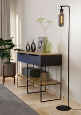 Moderne Stehleuchte MAIONE mit schwarzem Gestell und dekorativer Glühbirne, seitliche Perspektive im Wohnzimmer.