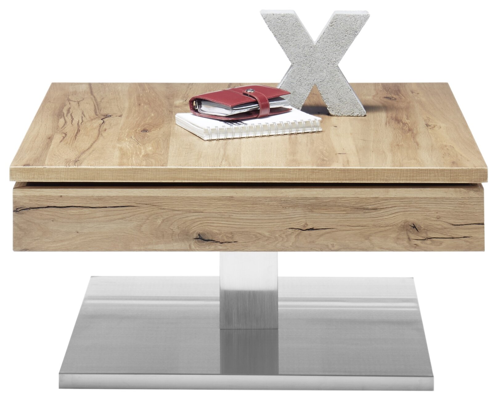 Moderne houten salontafel met metalen onderstel, gefotografeerd van voren, versierd met een notitieboekje, een rood etui en een betonnen letter X.