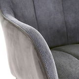Nahaufnahme eines grauen Armlehnstuhls mit weicher Polsterung und texturierter Oberfläche, seitliche Perspektive