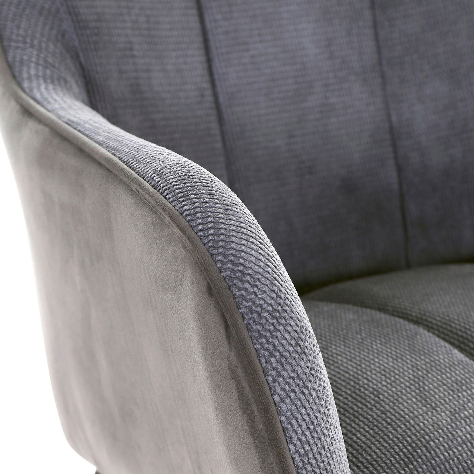 Nahaufnahme eines grauen Armlehnstuhls mit weicher Polsterung und texturierter Oberfläche, seitliche Perspektive