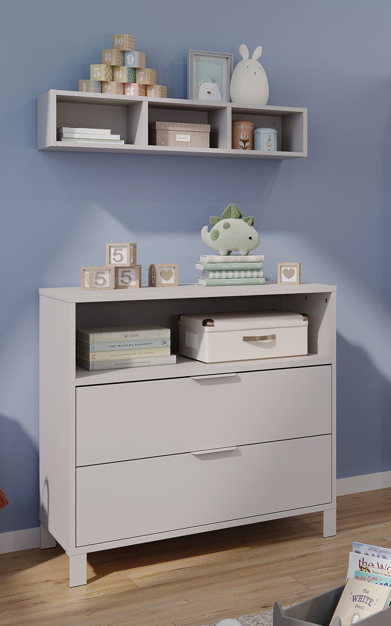 Germania Kommode schmal ALKMAAR Weiße, schmale Kommode mit zwei Schubladen und einem offenen Fach, dekoriert mit Spielzeug und Büchern, in einem Kinderzimmer. Perspektive von vorne.