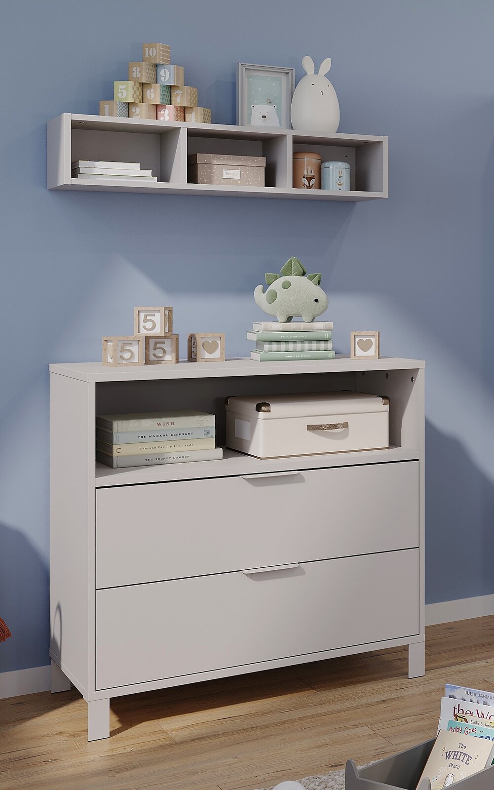 Germania Kommode schmal ALKMAAR Weiße, schmale Kommode mit zwei Schubladen und einem offenen Fach, dekoriert mit Spielzeug und Büchern, in einem Kinderzimmer. Perspektive von vorne.