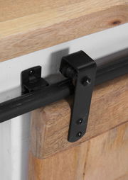 Nahaufnahme eines schwarzen Metallschiebers auf einem hölzernen Sideboard, seitliche Perspektive.