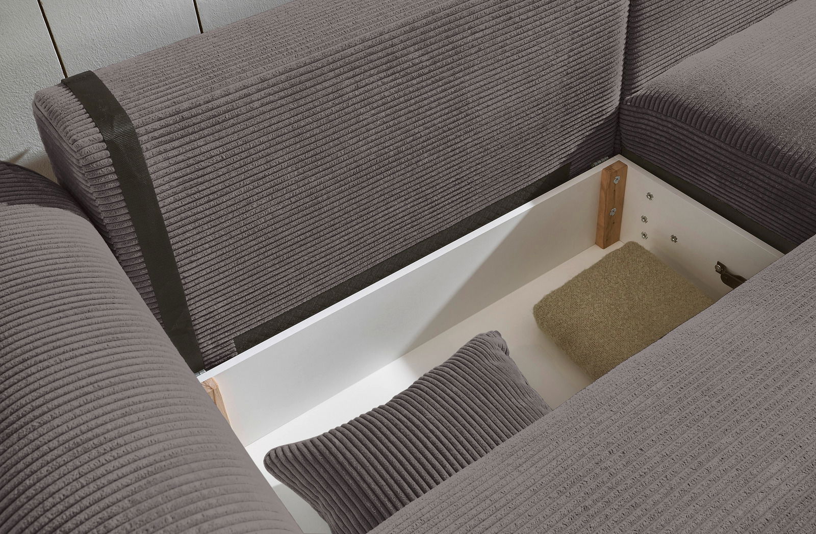 Innenansicht einer grauen Rundecke mit Stauraum, von oben betrachtet.