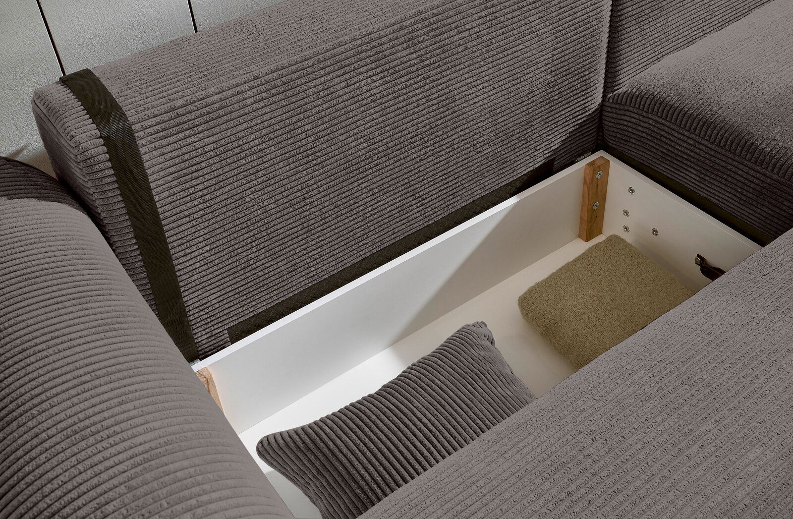 Innenansicht einer grauen Rundecke mit Stauraum, von oben betrachtet.