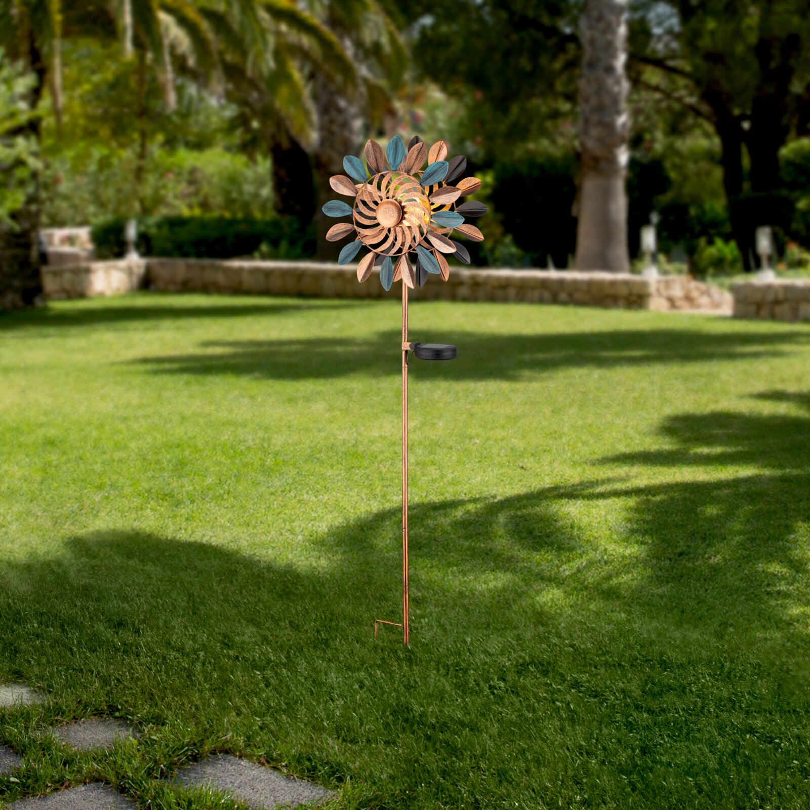 Zonne-lamp in de vorm van een decoratieve windmolen op een weide, zijaanzicht