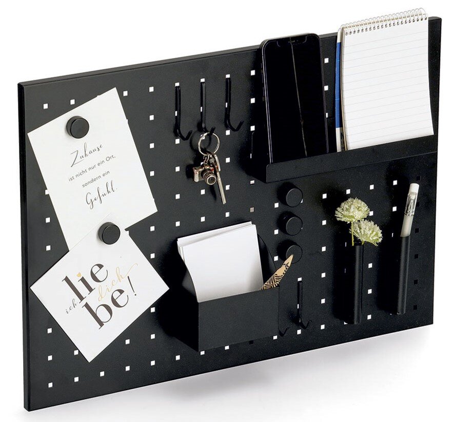 Schwarzes Memoboard mit Utensilien, darunter Haken für Schlüssel, Halterungen für Notizblöcke und Stifte, sowie dekorative Elemente. Perspektive: leicht von oben.