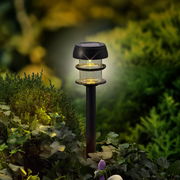 Solarbetriebene Stabbeleuchtung aus Plastik in einem Garten, seitliche Perspektive