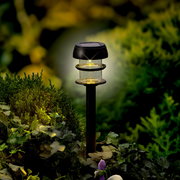 Solarbetriebene Stabbeleuchtung aus Plastik in einem Garten, seitliche Perspektive