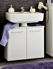Moderner weißer Waschbeckenunterschrank mit zwei Türen, frontal fotografiert, unter einem Waschbecken montiert. Dekoriert mit einem lila Handtuch und Badezimmerutensilien.