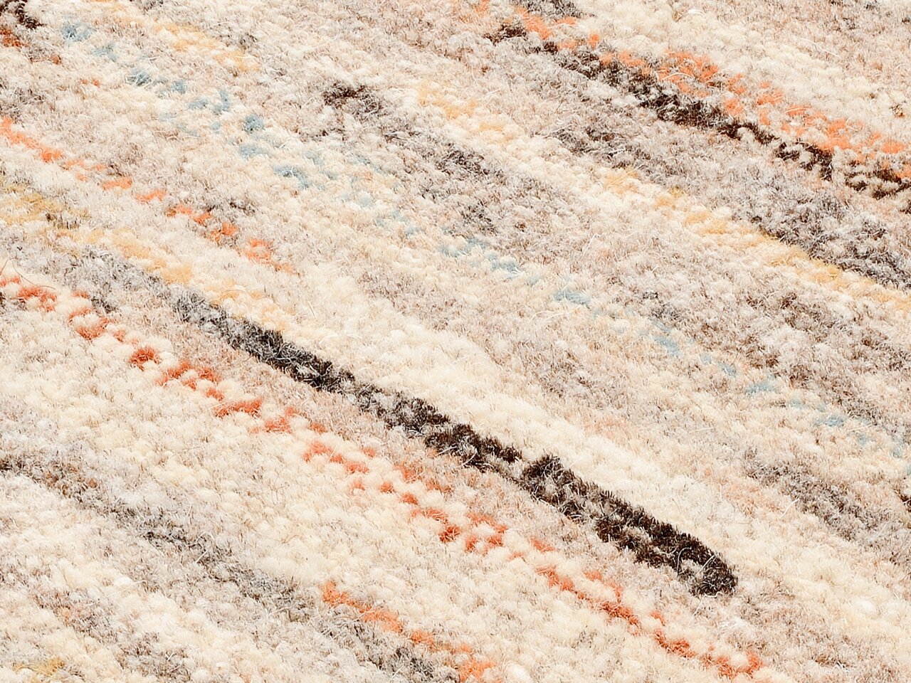 Nahaufnahme eines Wollteppichs mit bunten Streifen in Beige, Orange, Blau und Braun.
