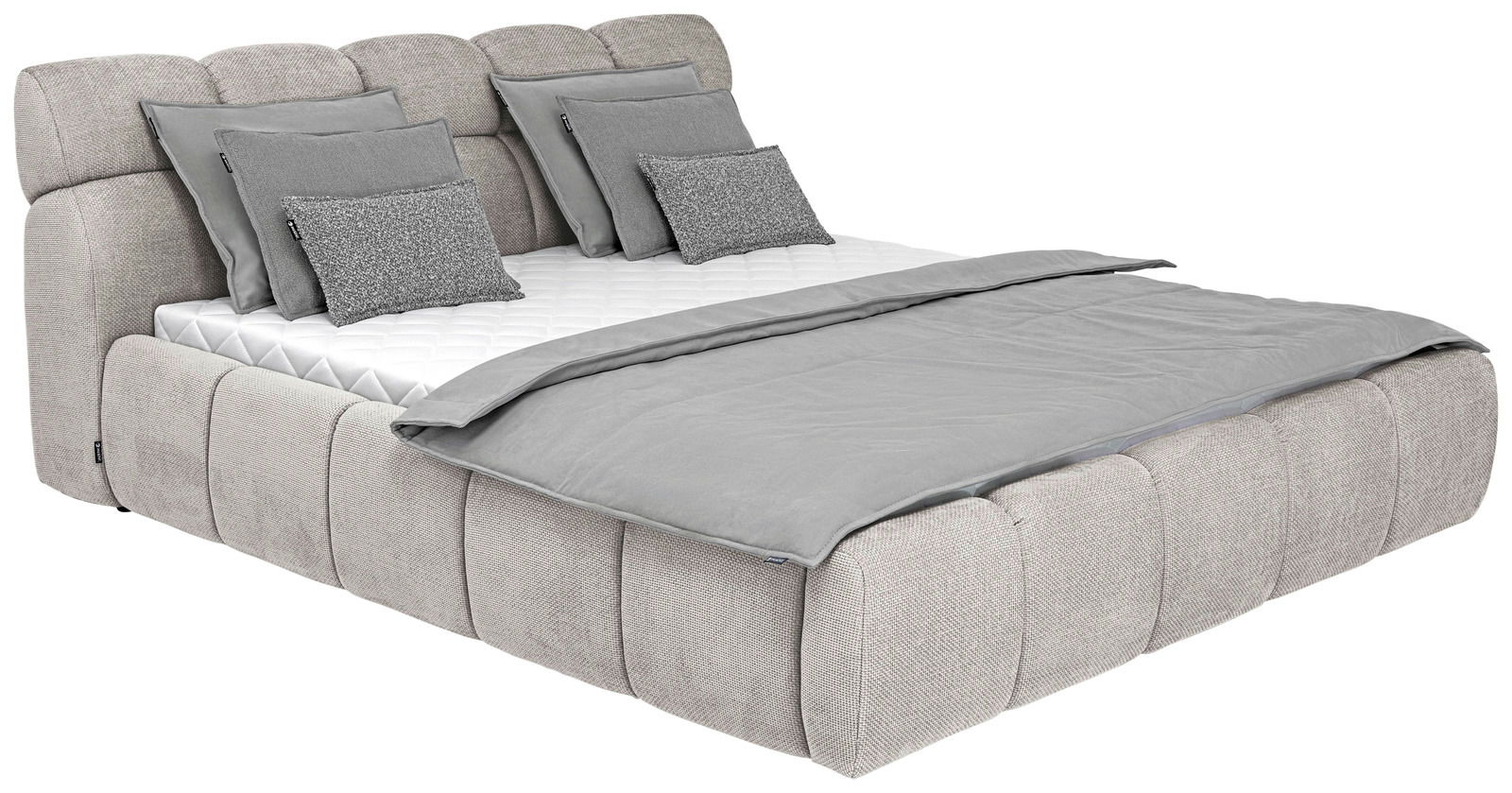 Graues Polsterbett mit mehreren Kissen und Decke, seitliche Perspektive