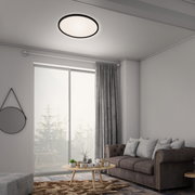 Moderne LED-Deckenleuchte in einem stilvollen Wohnzimmer, von unten betrachtet.