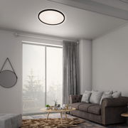 Moderne LED-Deckenleuchte in einem stilvollen Wohnzimmer, von unten betrachtet.