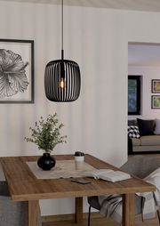 Moderne schwarze Pendelleuchte Romazzina in einem gemütlichen Esszimmer, aus seitlicher Perspektive fotografiert.