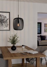 Moderne schwarze Pendelleuchte Romazzina in einem gemütlichen Esszimmer, aus seitlicher Perspektive fotografiert.