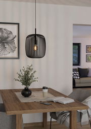 Moderne schwarze Pendelleuchte Romazzina in einem gemütlichen Esszimmer, aus seitlicher Perspektive fotografiert.