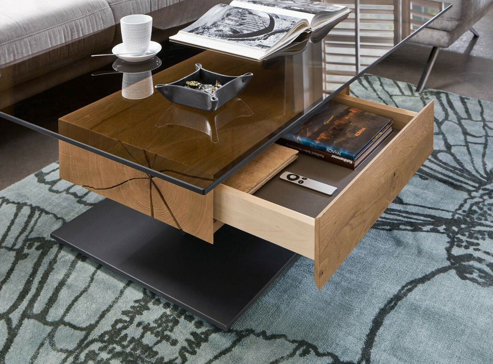 Moderner Couchtisch mit Glasplatte und Holzschublade, seitliche Perspektive