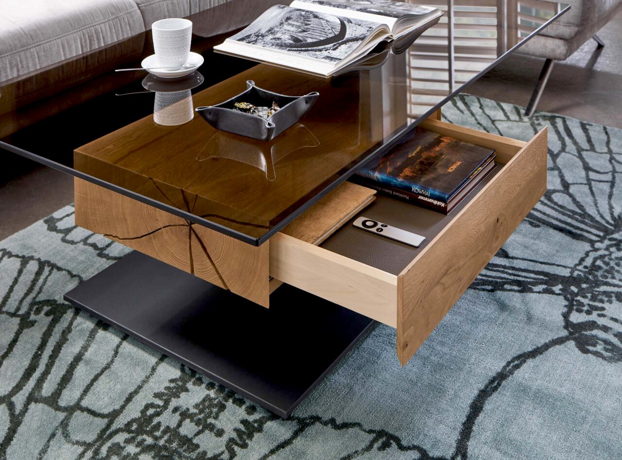 Moderner Couchtisch mit Glasplatte und Holzschublade, seitliche Perspektive