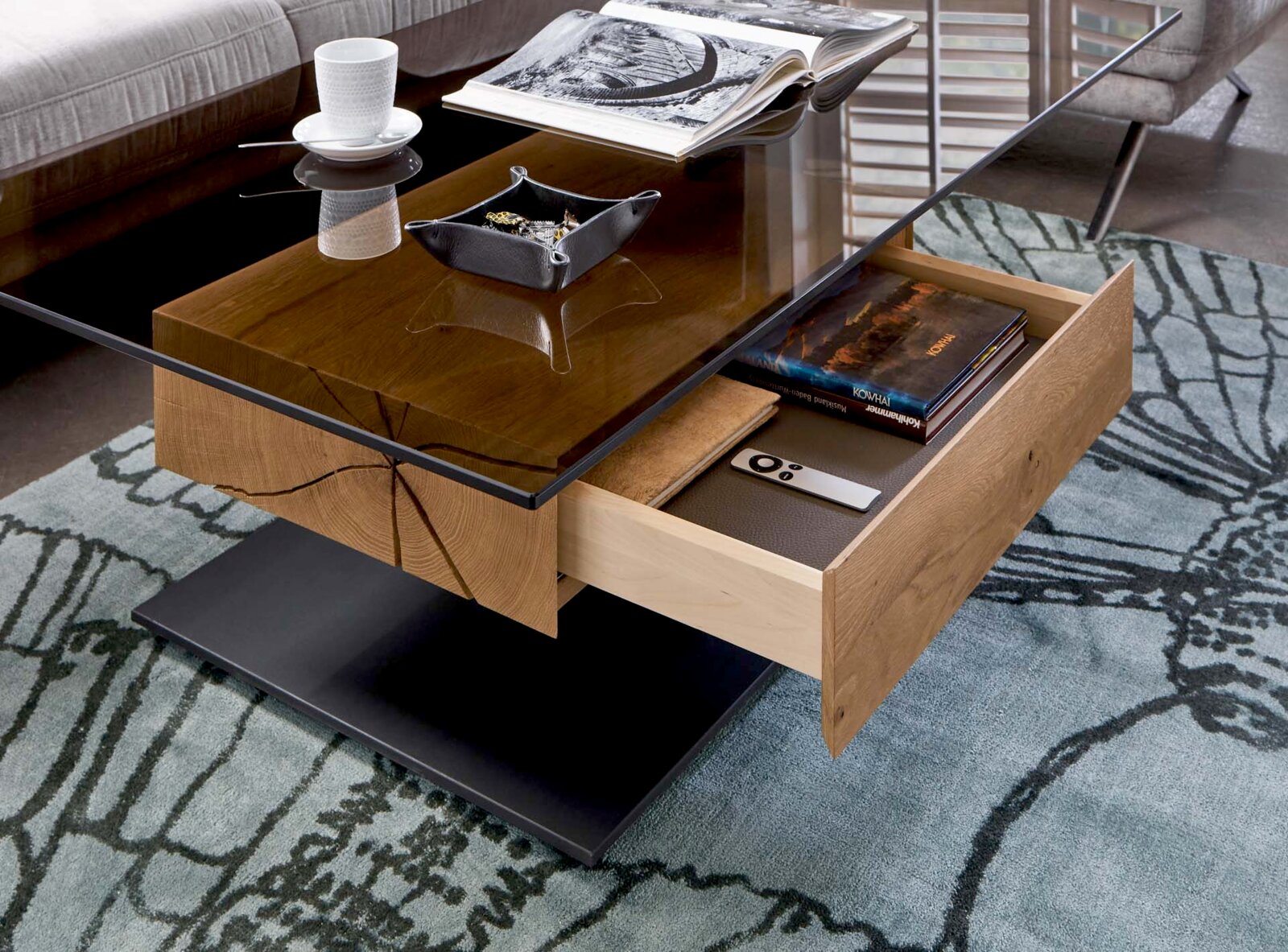 Moderner Couchtisch mit Glasplatte und Holzschublade, seitliche Perspektive