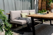 Gartensitzgruppe mit modernem Holztisch und bequemer Sitzbank, seitliche Perspektive