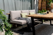 Gartensitzgruppe mit modernem Holztisch und bequemer Sitzbank, seitliche Perspektive
