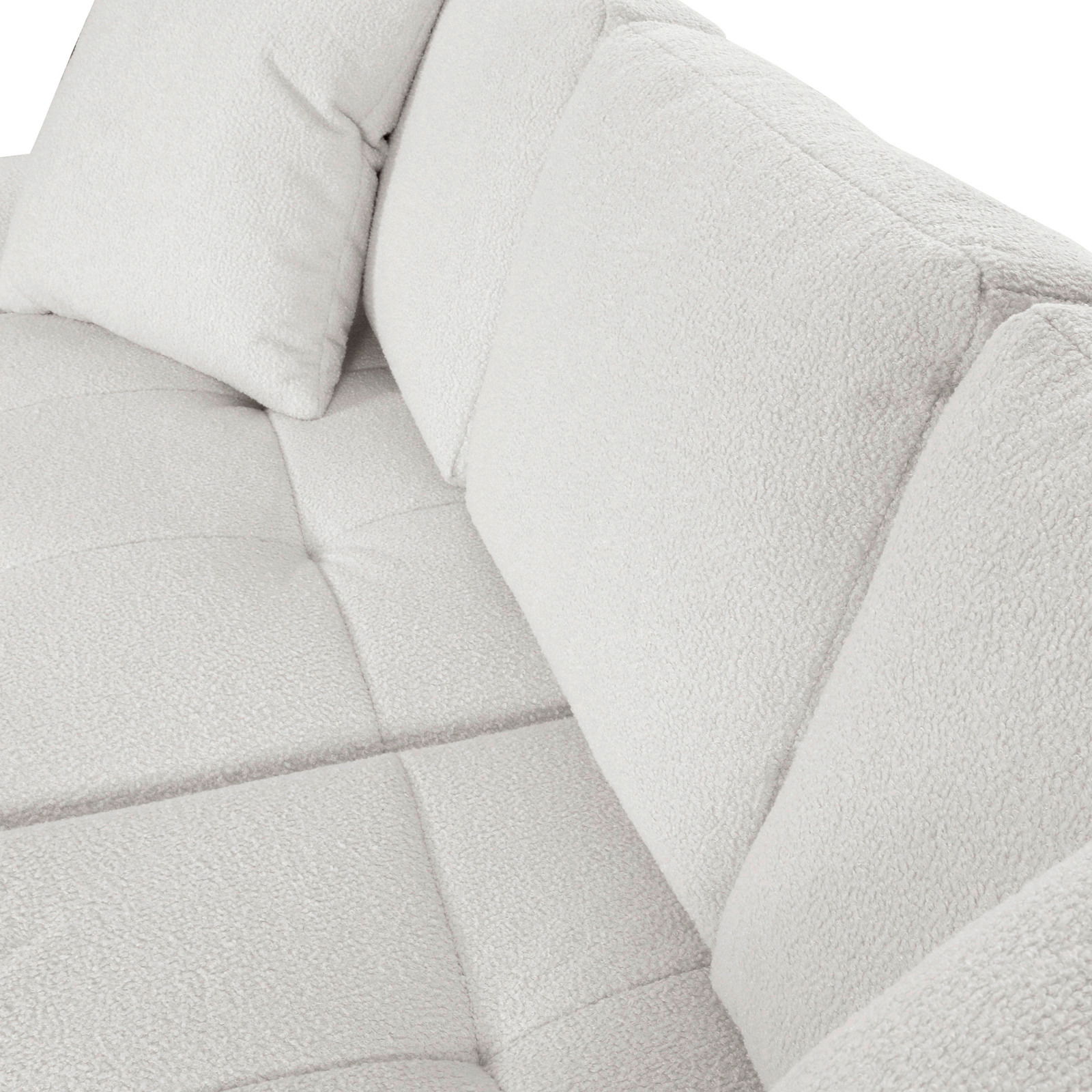 Nahaufnahme einer hellen, strukturierten Sofaecke mit Kissen, Perspektive von oben.
