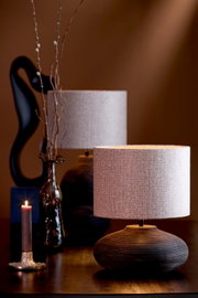 Stilvolle Tischlampe mit rundem, strukturiertem Lampenschirm und elegantem Sockel, seitliche Perspektive
