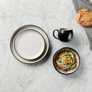 Kombiservice 16-tlg. aus der Vogelperspektive, bestehend aus zwei Tellern, einer Tasse und einer Schüssel mit Salat auf einem Marmortisch.