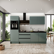 Moderne Küchenzeile in mattem Grün mit integriertem Backofen und Dunstabzugshaube, seitliche Perspektive mit Blick auf große Fenster und viel Tageslicht.