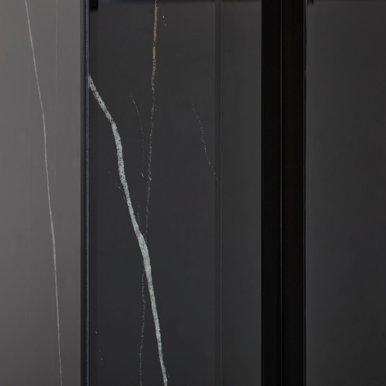 Nahaufnahme eines Konsolentisches mit dunkler Oberfläche und feinen, hellen Adern, vertikale Perspektive.