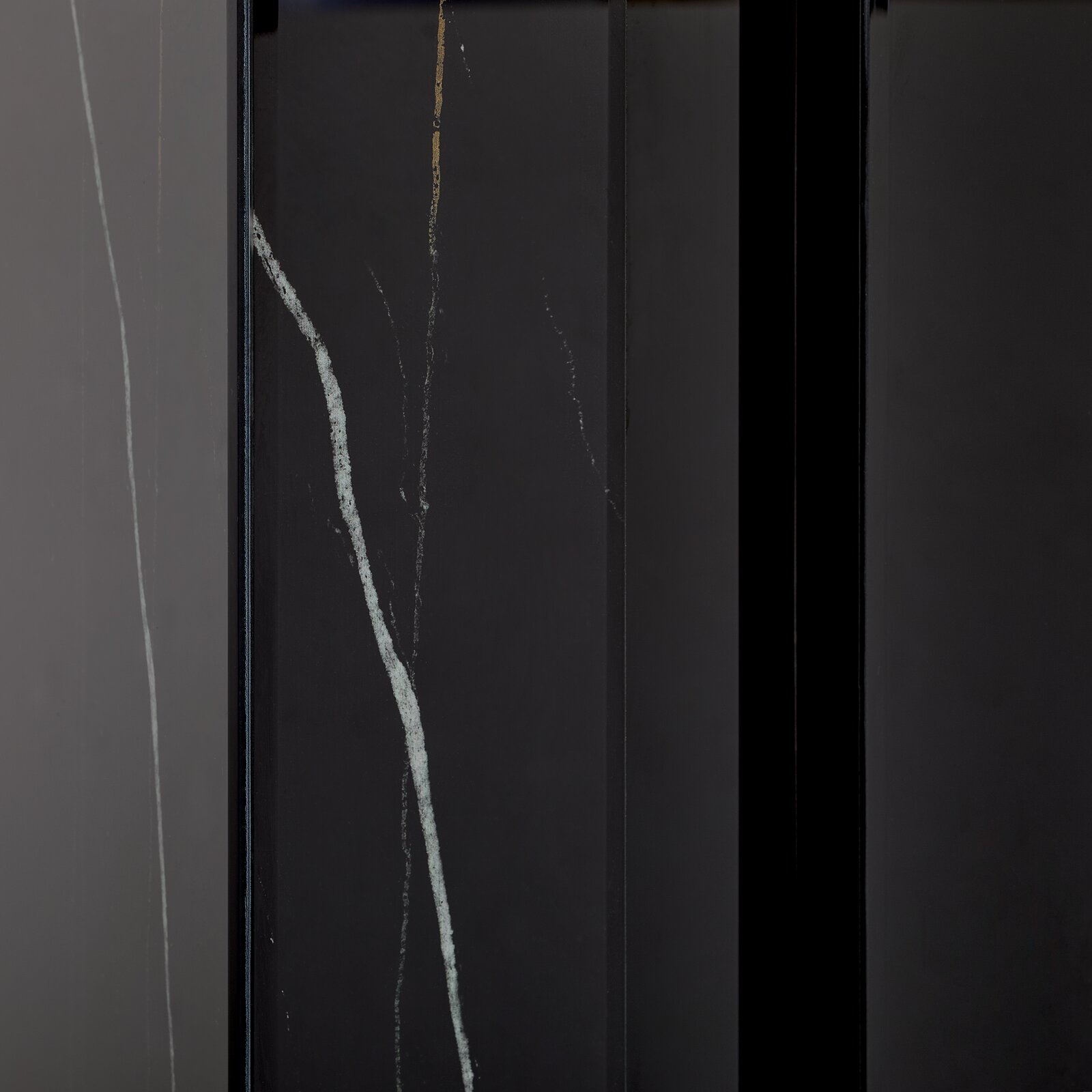 Nahaufnahme eines Konsolentisches mit dunkler Oberfläche und feinen, hellen Adern, vertikale Perspektive.