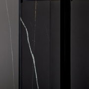 Nahaufnahme eines Konsolentisches mit dunkler Oberfläche und feinen, hellen Adern, vertikale Perspektive.