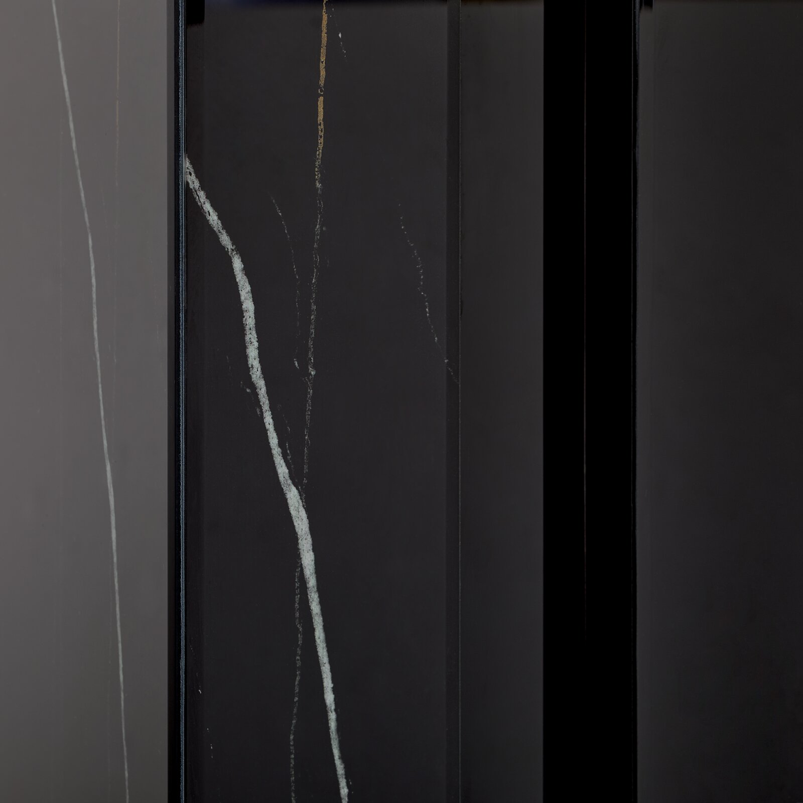 Nahaufnahme eines Konsolentisches mit dunkler Oberfläche und feinen, hellen Adern, vertikale Perspektive.