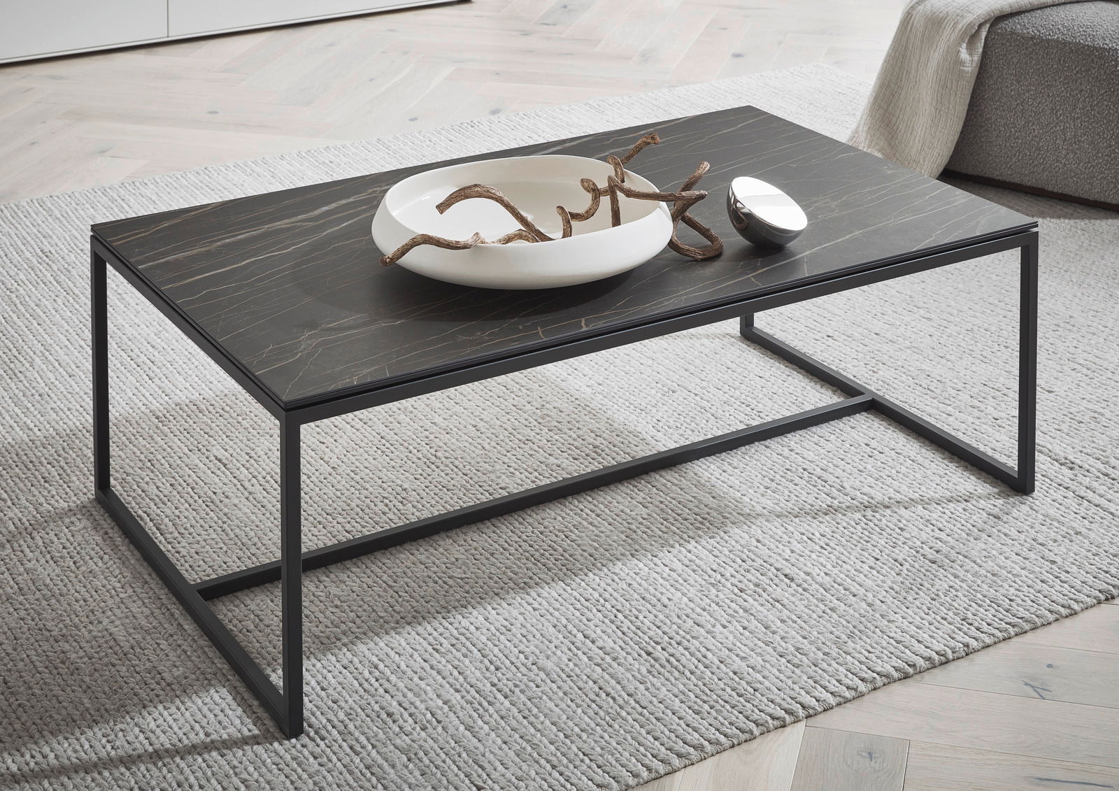 Dieter Knoll Couchtisch MONTESA Moderner Couchtisch mit schwarzer Marmoroptik-Oberfläche und schlankem Metallrahmen, seitliche Perspektive.