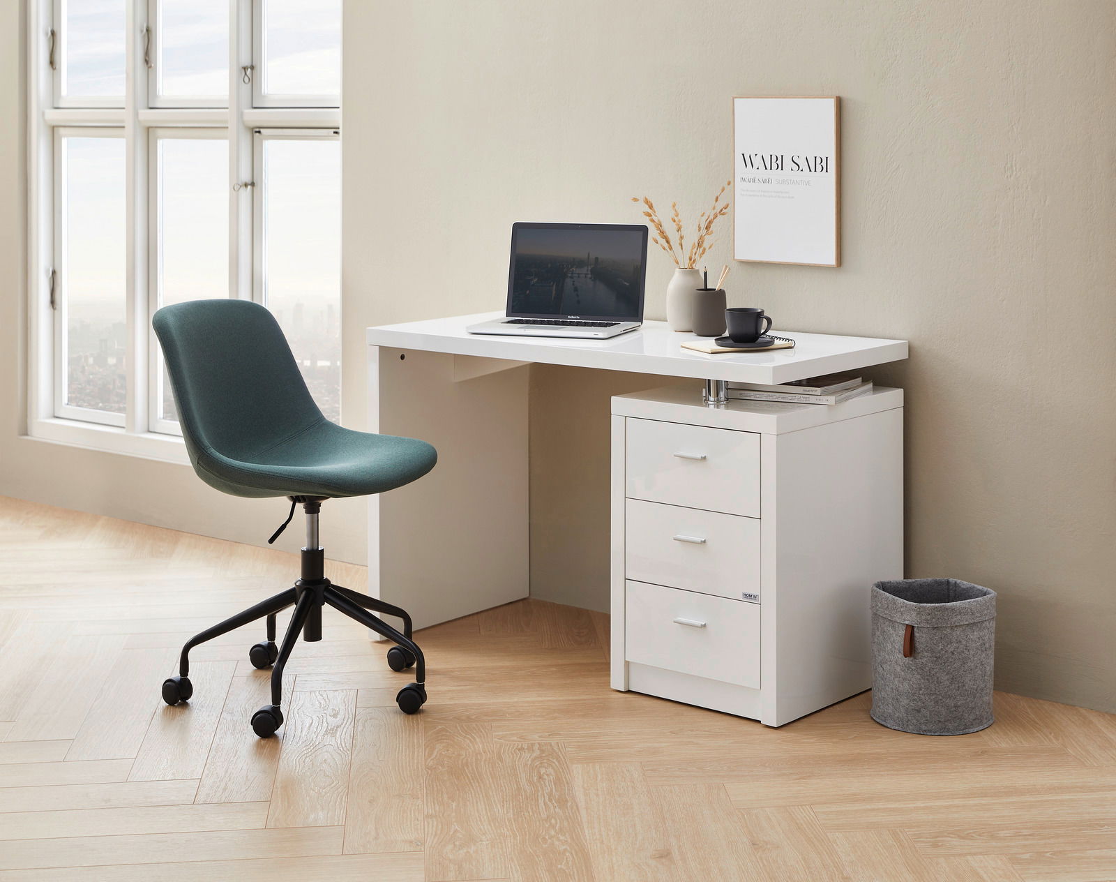 Moderner Home Office Drehstuhl in Grün, seitliche Perspektive, neben einem weißen Schreibtisch mit Laptop und Dekoration.