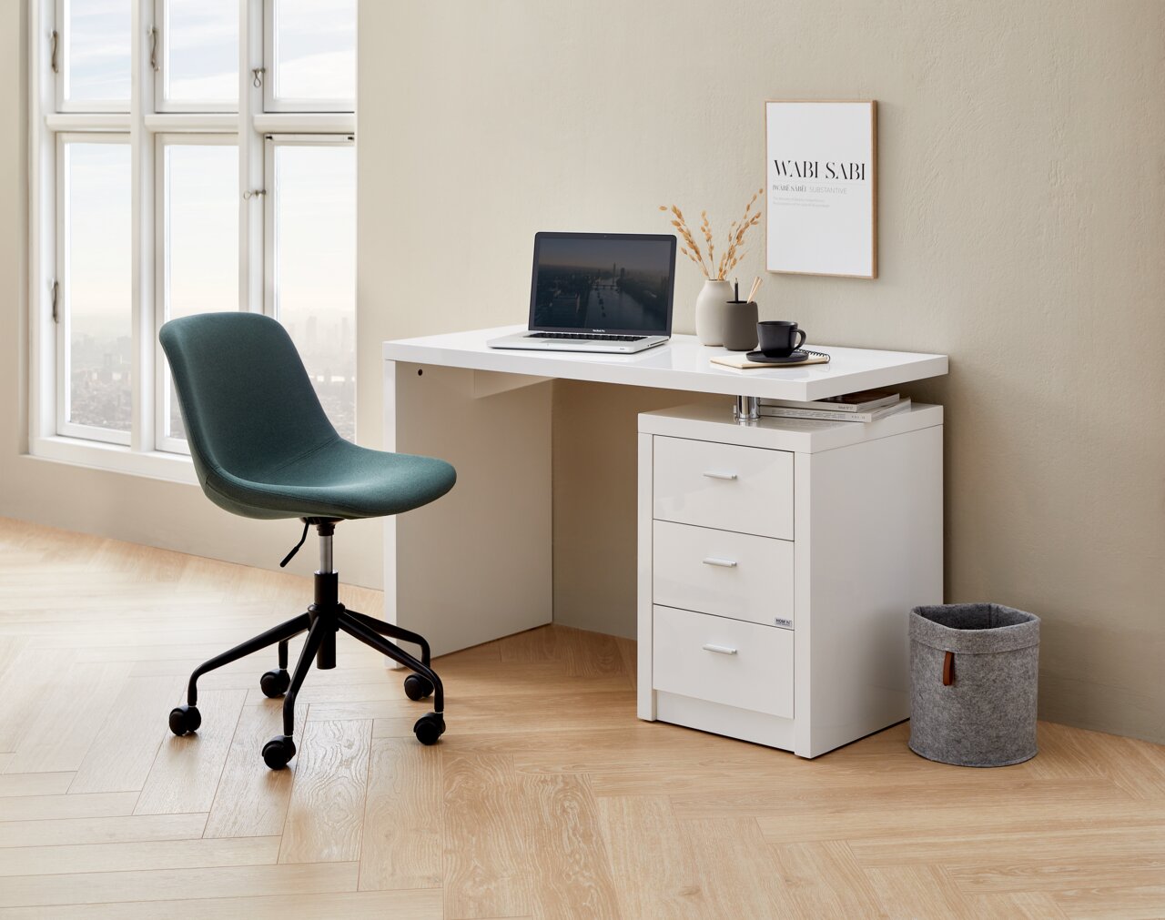 Hom´in Home Office Drehstuhl Siegbert Moderner Home Office Drehstuhl in Grün, seitliche Perspektive, neben einem weißen Schreibtisch mit Laptop und Dekoration.