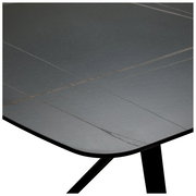 Nahaufnahme eines Gartentisches mit grauer, glatter Oberfläche und abgerundeten Ecken, aus seitlicher Perspektive.