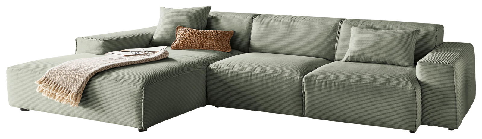 Grüne Ecksofa mit Ottomane links, dekoriert mit Kissen und Decke, seitliche Perspektive
