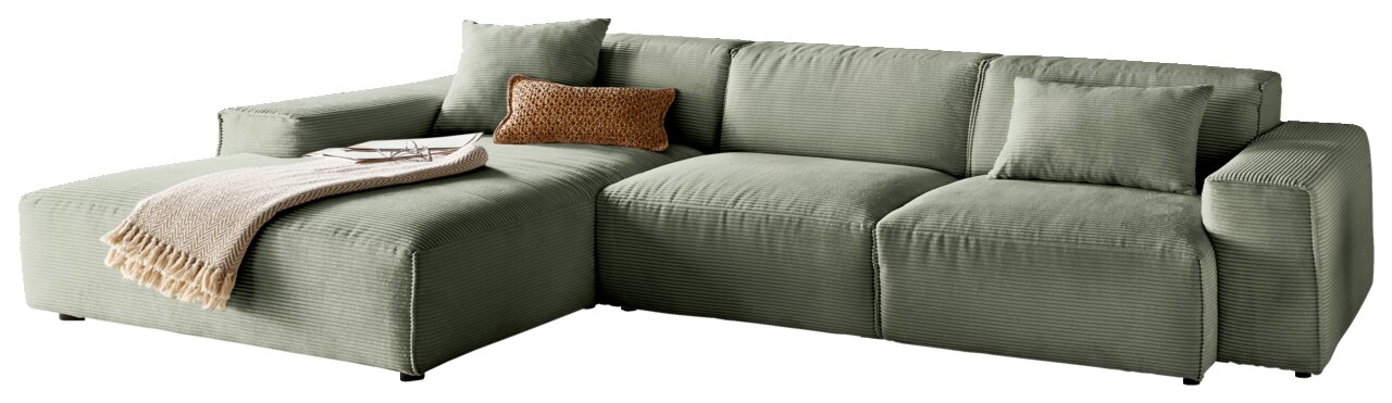 Grüne Ecksofa mit Ottomane links, dekoriert mit Kissen und Decke, seitliche Perspektive