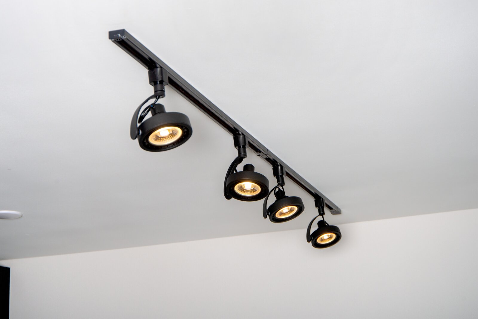 Zwarte spot DORIAN TRACK van Lucide, aan het plafond gemonteerd, met vier verstelbare lampen, zijaanzicht.