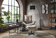 Moderner Relaxsessel mit Hocker in einem stilvollen Wohnzimmer, seitliche Perspektive.