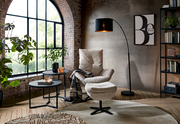 Moderner Relaxsessel mit Hocker in einem stilvollen Wohnzimmer, seitliche Perspektive.