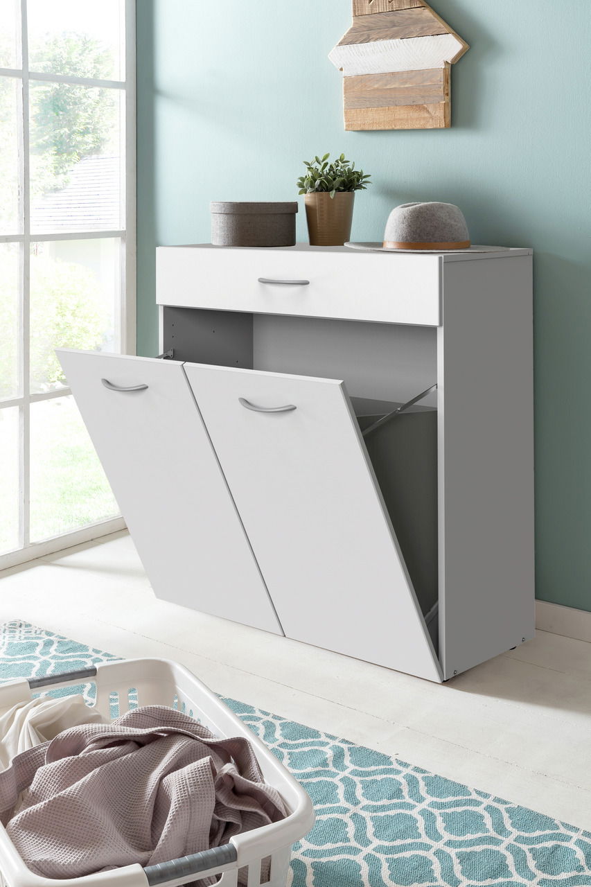 Weiße Wäschekommode mit zwei offenen Klappen und einer Schublade, seitliche Perspektive, dekoriert mit Pflanze und Hut.