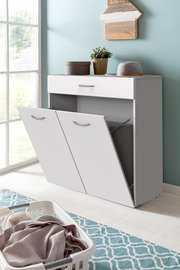 Weiße Wäschekommode mit zwei offenen Klappen und einer Schublade, seitliche Perspektive, dekoriert mit Pflanze und Hut.