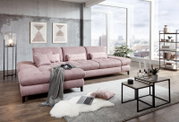 Grote, moderne hoekbank in roze met kussens, in een stijlvolle woonkamer met grote ramen en uitzicht op de stad, gefotografeerd vanuit een zijdelingse hoek.
