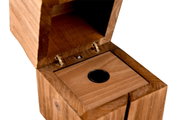 Close-up van een geopende houten kist met scharnieren en een ronde opening, in perspectief van bovenaf gezien.